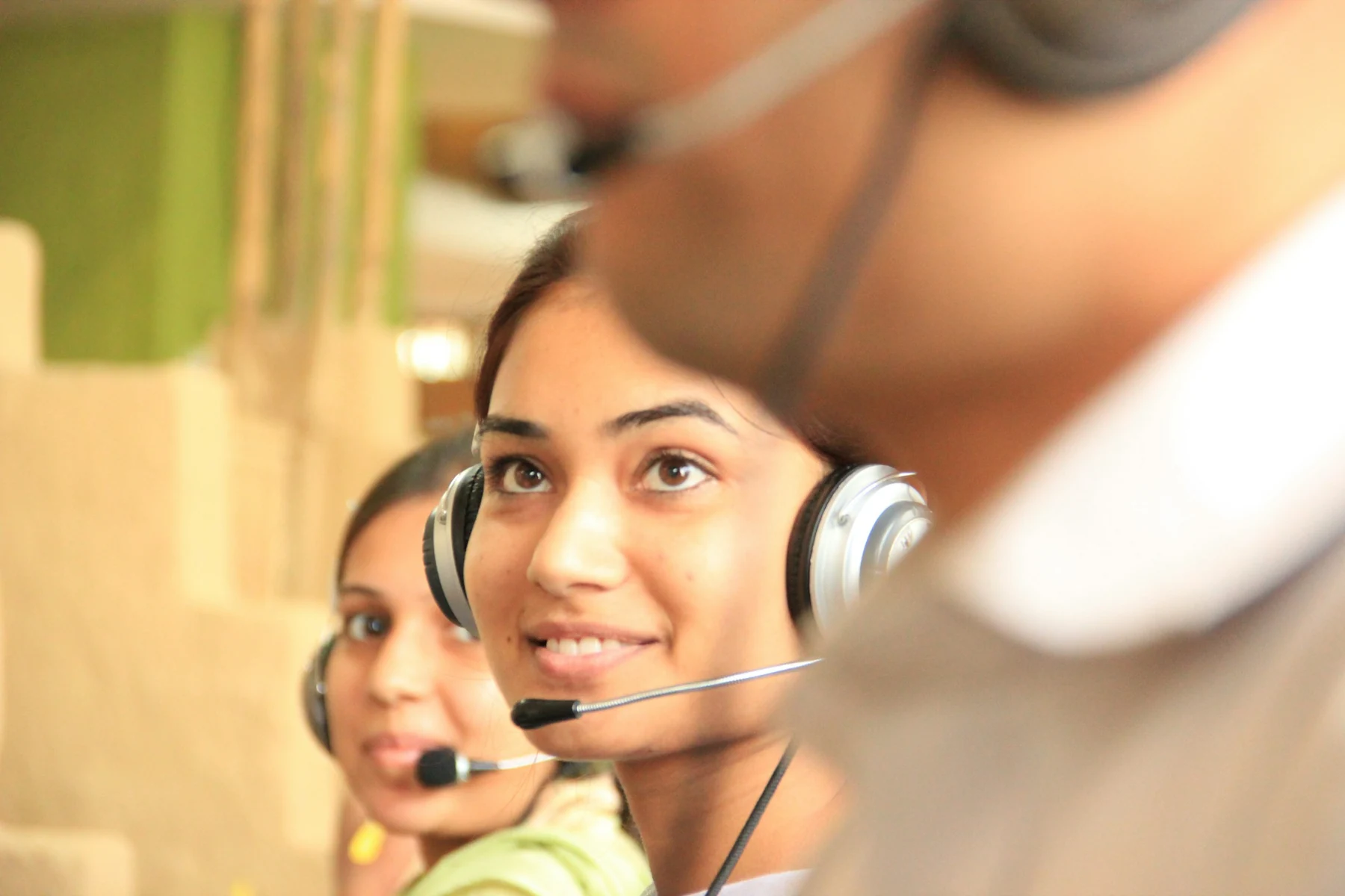 Customer support representatives wearing headsets in an office
