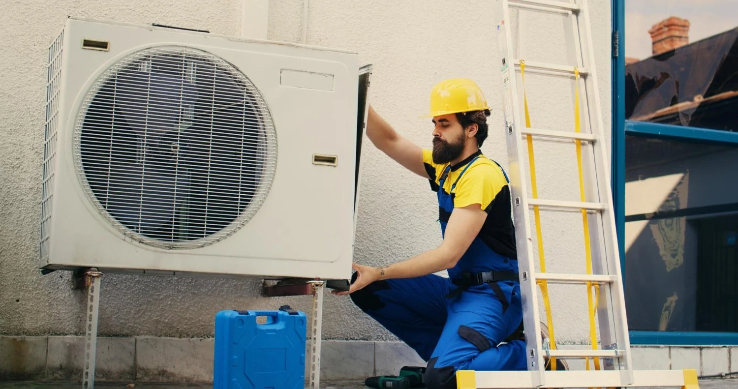 Technician inspecting an outdoor air conditioning unit