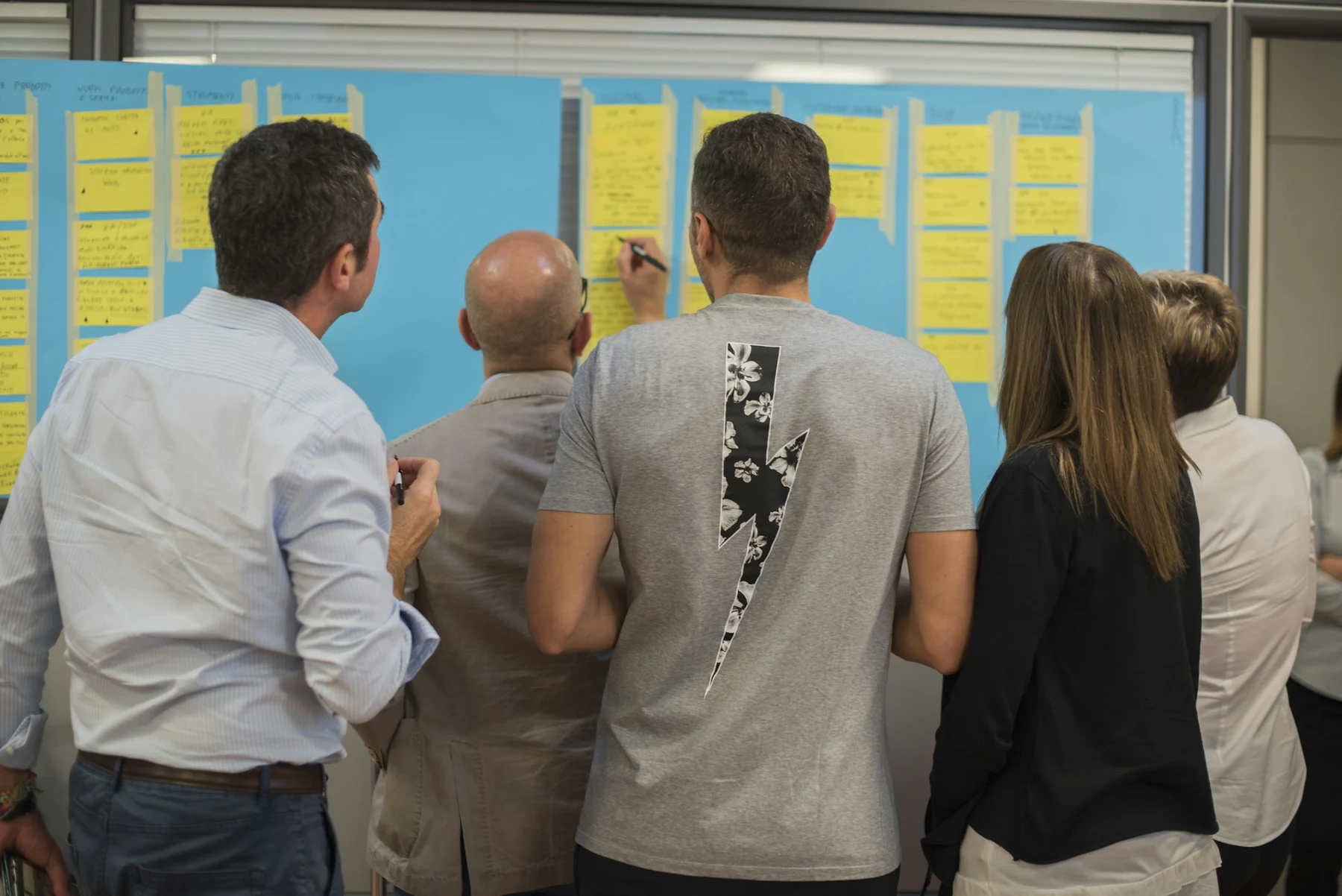 Workshop participants reviewing sticky notes on a planning board